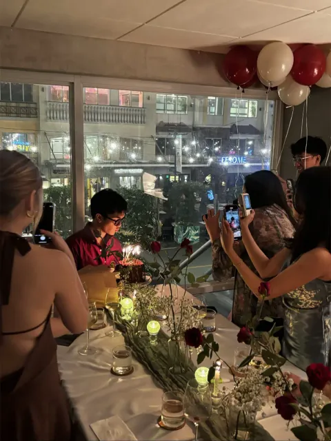 TikTok slideshow cover: A group of people celebrating at a dinner table